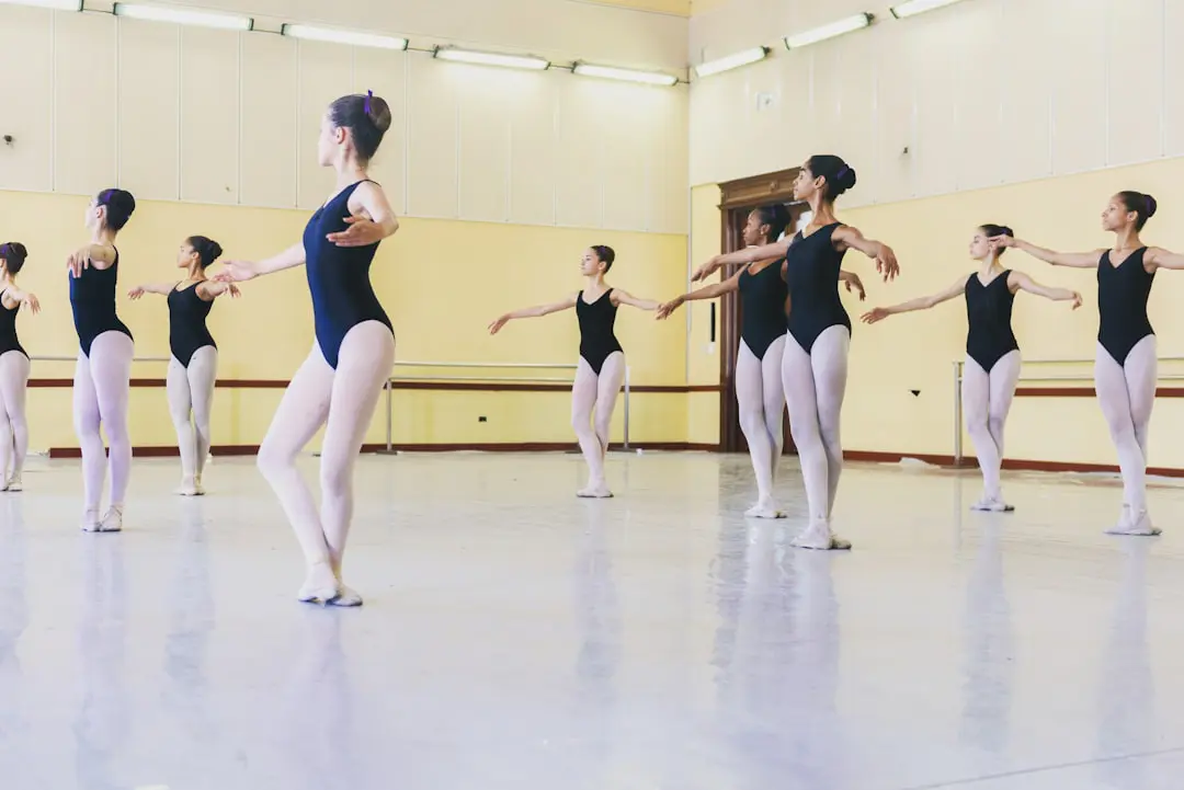 Ballet class in black leotards and pink tights in a dance studio